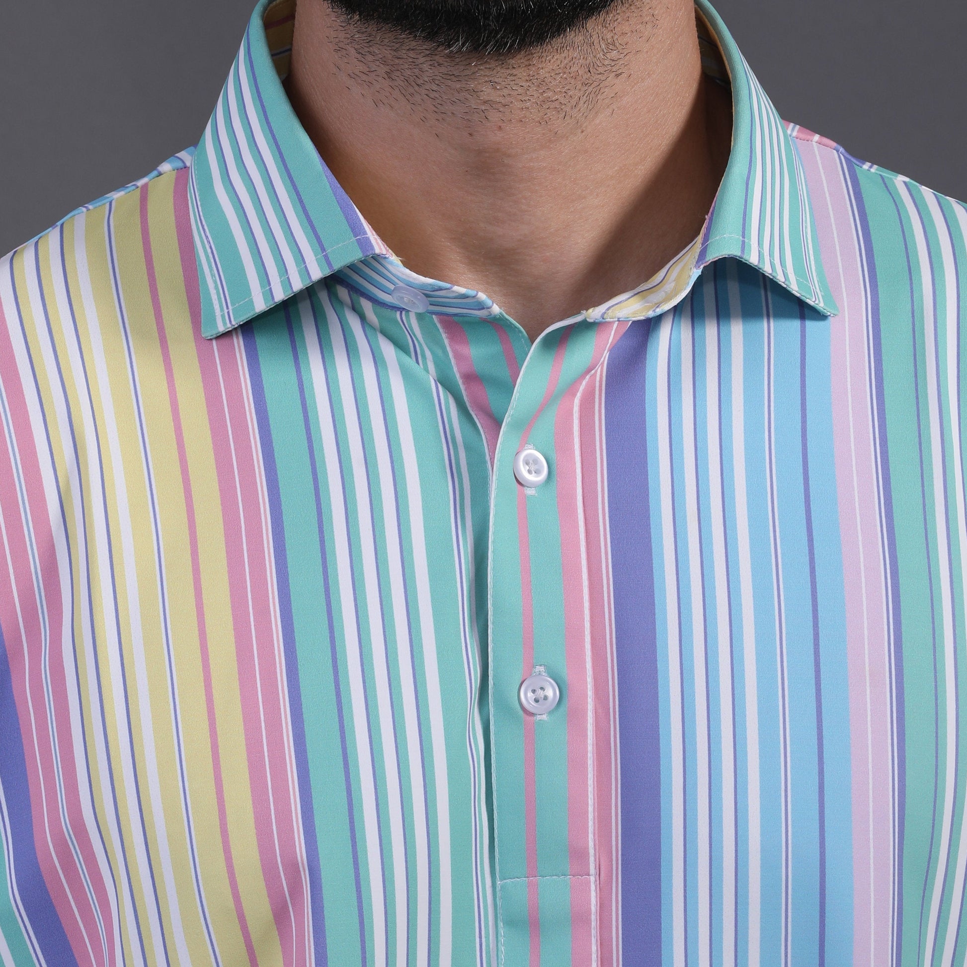 Man wearing a colorful striped shirt against a gray background