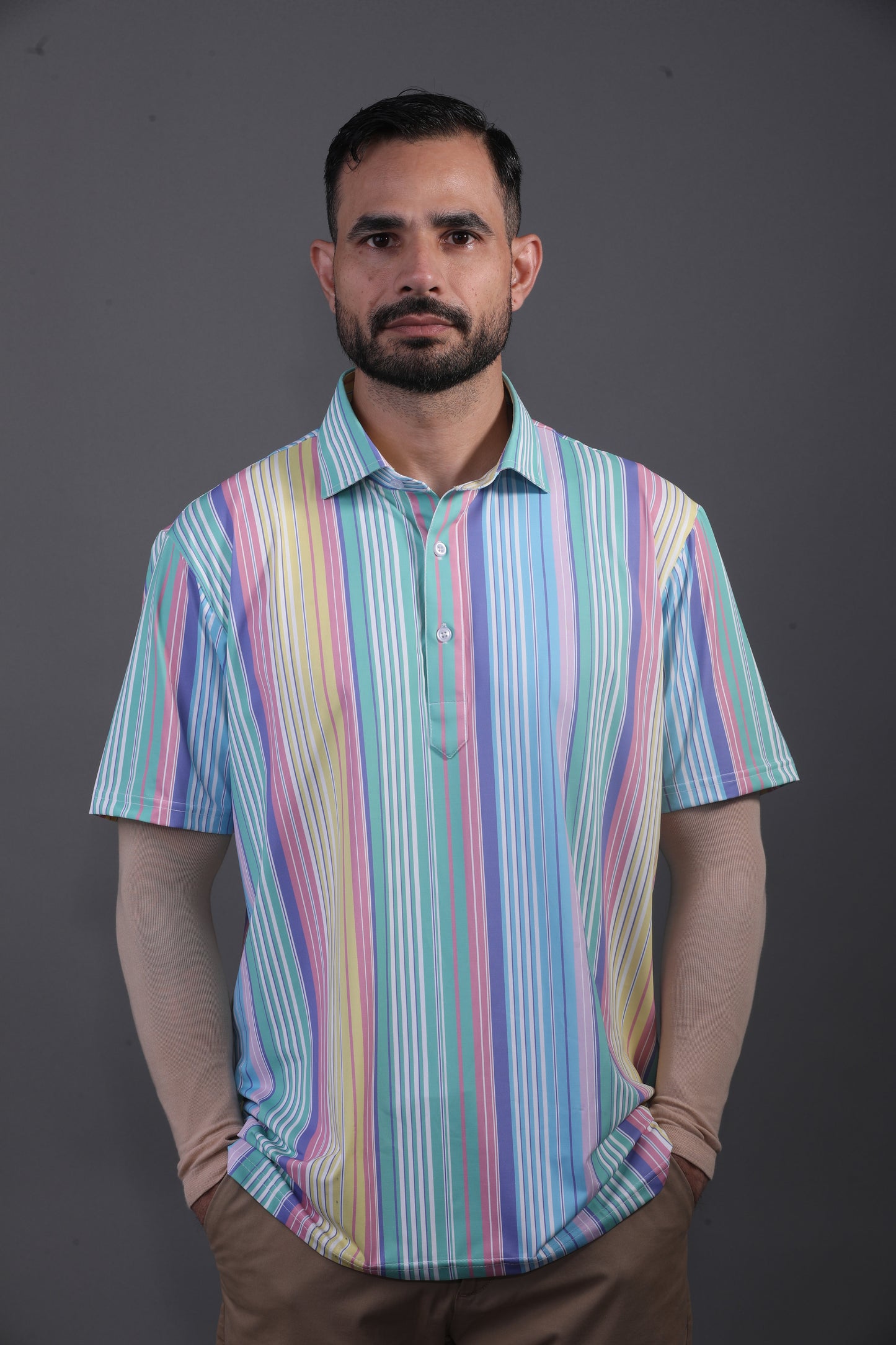 Man wearing a colorful striped shirt against a gray background