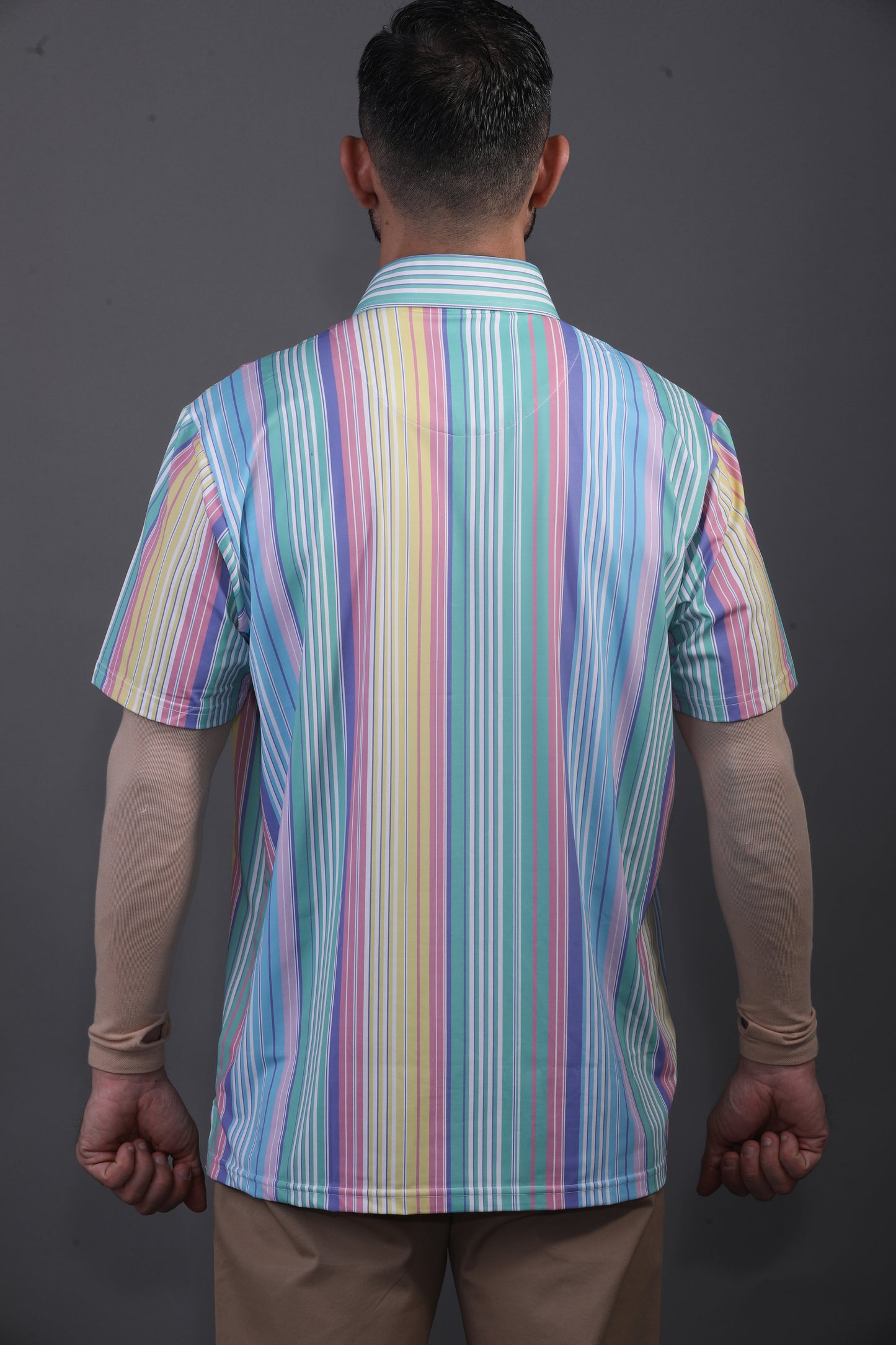 Person wearing a colorful striped shirt against a gray background
