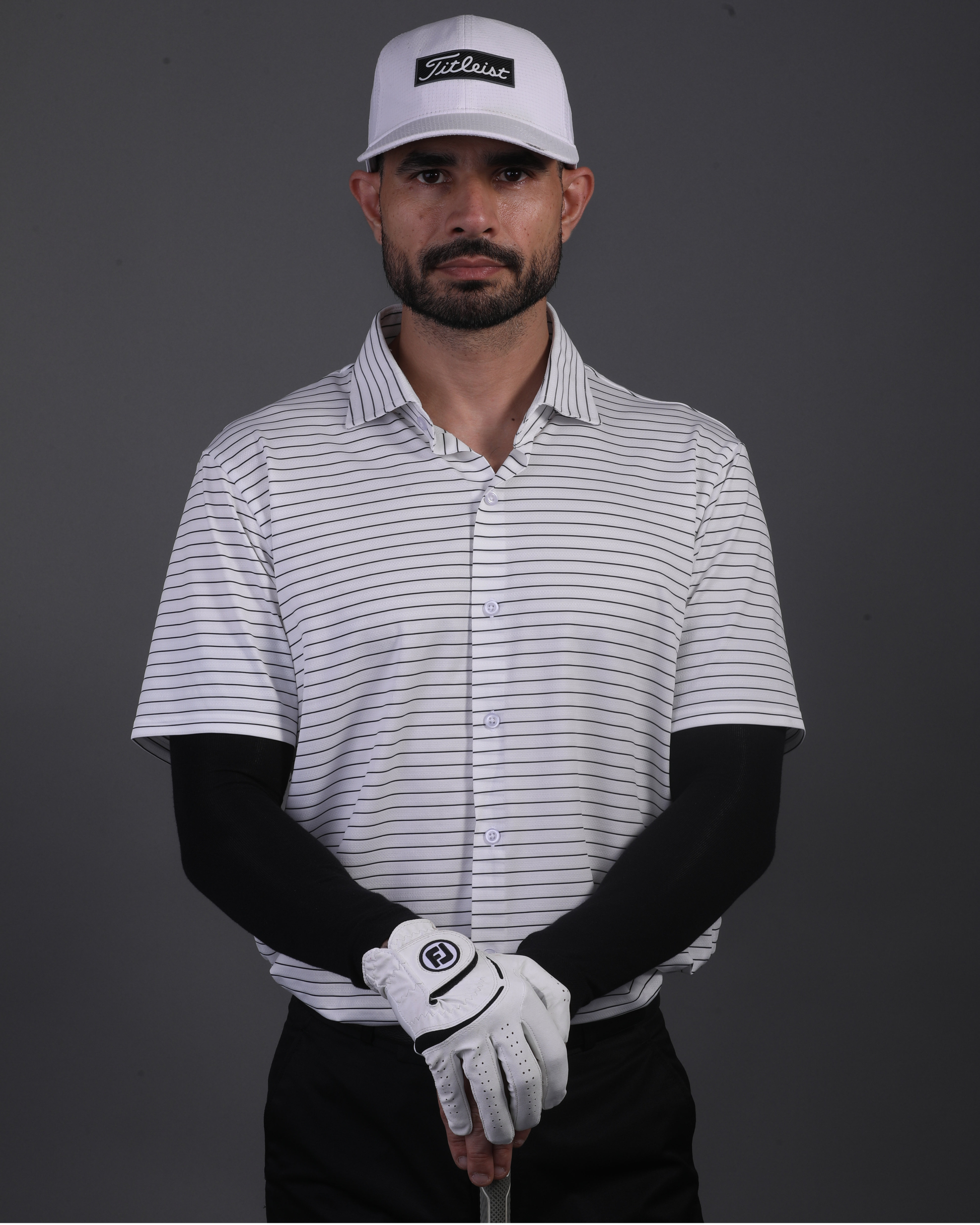 Model wearing DapperTee striped open polo for a premium corporate boardroom aesthetic.