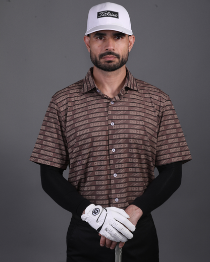 Model wearing DapperTee brown open polo for a premium corporate boardroom aesthetic.