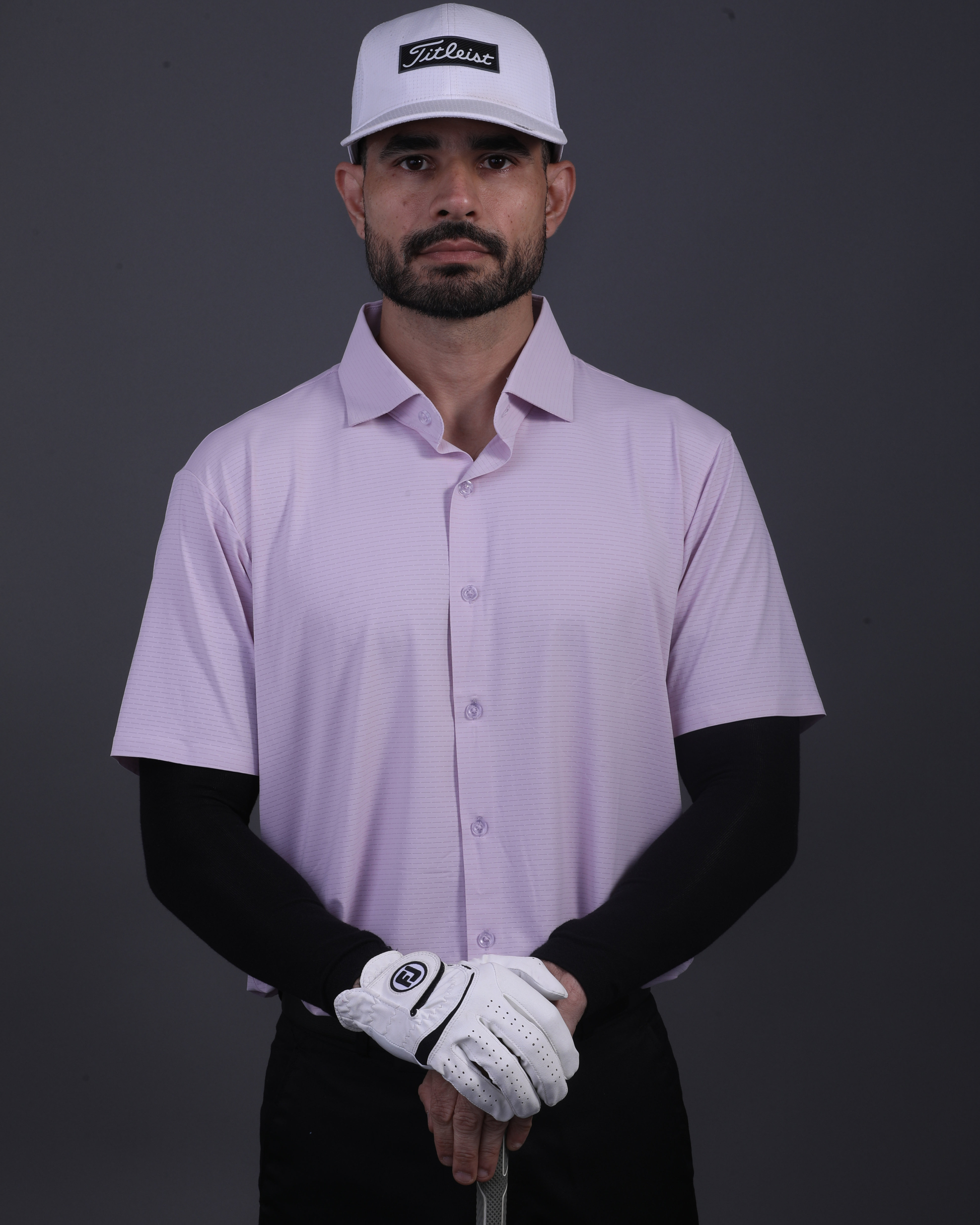 Model wearing DapperTee pink open polo for a premium corporate boardroom aesthetic.