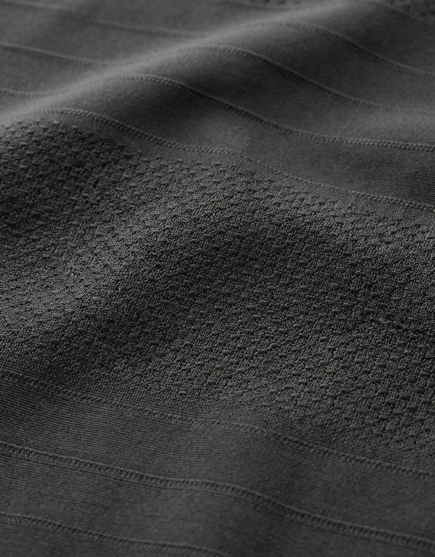 Close-up specialized jacquard polyamide fabric texture on DapperTee Scotland Yard office polo.