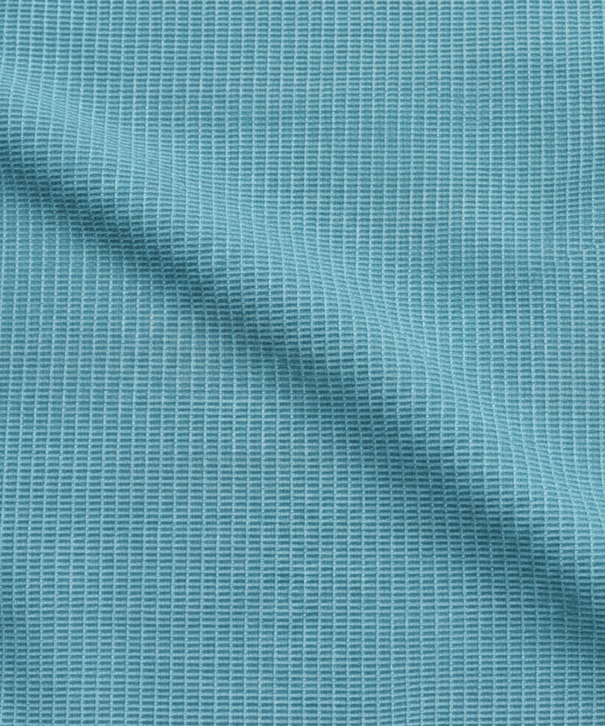 Close-up specialized jacquard polyamide fabric texture on DapperTee Super light teal shirt.