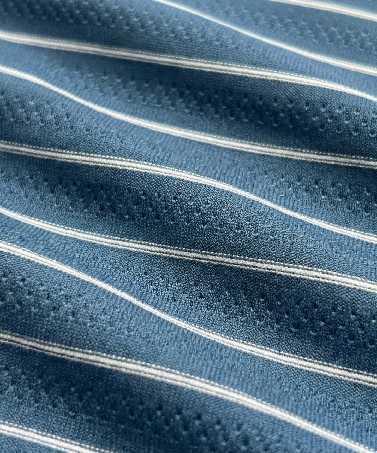 Close-up specialized jacquard polyamide fabric texture on DapperTee navy blue striper shirt.